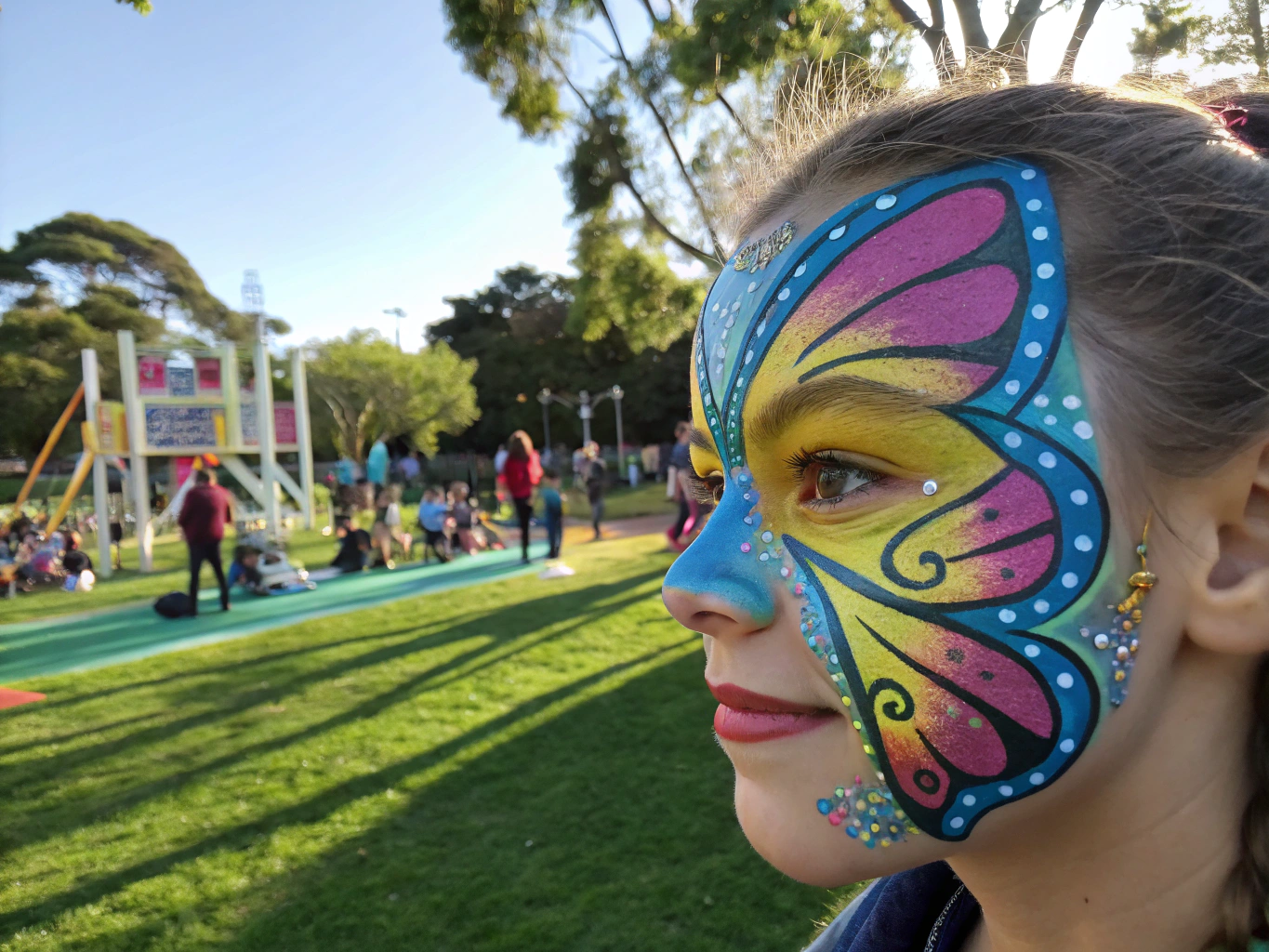 Vibrant butterfly face painting mask with sunset gradients on a smiling child